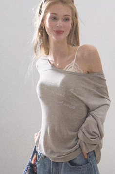 Blonde woman in an off-shoulder top and jeans with soft lighting