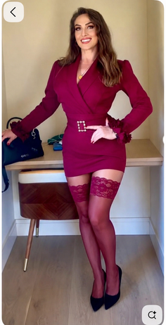 Woman in a burgundy dress and lace stockings posing indoors