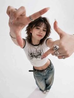 Young woman in a crop top and baggy jeans making a frame with her hands