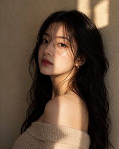 Woman with long black hair in an off-shoulder top with golden hour lighting