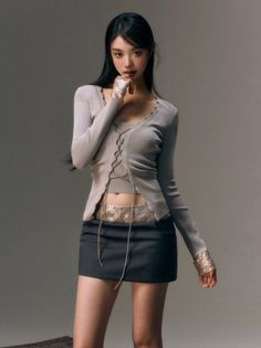 Woman in a cropped lace-up top and mini skirt with exposed midriff