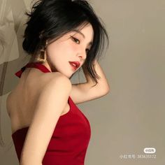 Woman with short black hair in a red dress with an exposed back