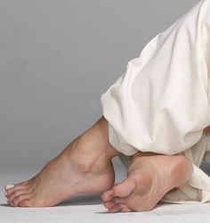 Bare feet with white toenails and white pants in a studio shot