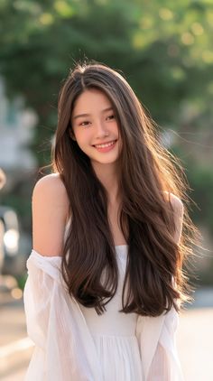 Young woman with long brown hair in a white dress with soft lighting