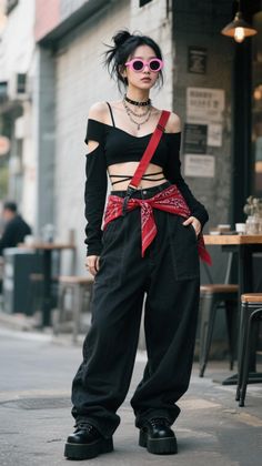 Woman in a black crop top, baggy pants, and pink sunglasses on a street