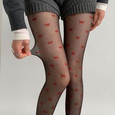 Person wearing black tights with red bows and knitted shorts