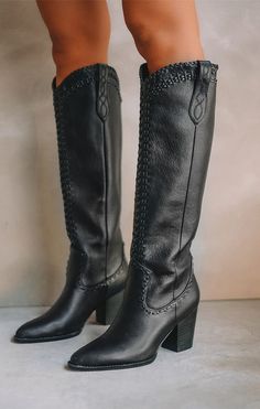 Pair of black knee-high leather boots with stitched details and block heels