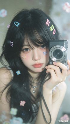 Woman with long black hair and colorful hair clips holding a camera