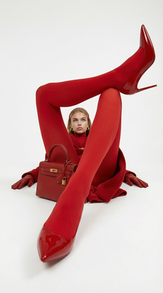 Woman in a red outfit and high heels posing on a white background