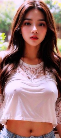 Woman with long hair wearing a white crop top with lace detail and exposed navel