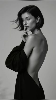 Woman with short hair in a black dress with an exposed back in a studio