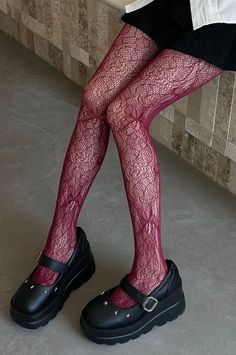 Person wearing red lace tights and black platform mary jane shoes