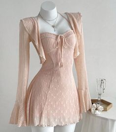 Pink dress and matching cardigan on a mannequin with jewelry