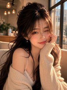 Woman with long dark hair winking and smiling in soft indoor lighting