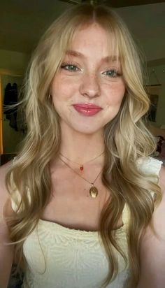 Blonde woman with freckles and long hair wearing necklaces