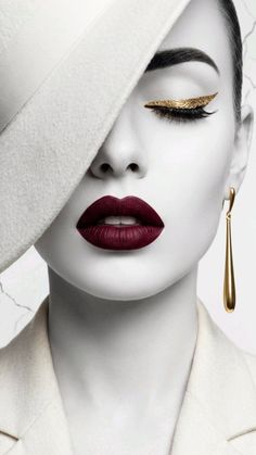 Woman in a white hat with gold eyeliner and dark red lipstick