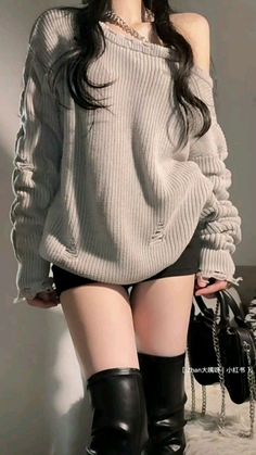 Person in a distressed sweater, black shorts, and thigh high boots