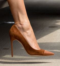Close up of a foot in a brown suede high heel shoe