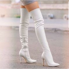 Person wearing white thigh-high boots and a short skirt