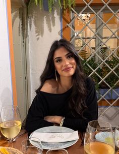 Woman with long dark hair wearing an off-shoulder top at a restaurant