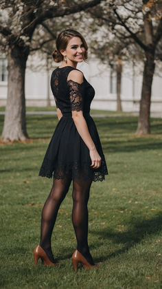 Woman in a black lace dress and brown heels standing on green grass