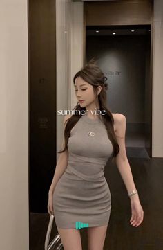 Woman in a gray bodycon dress with long hair indoors