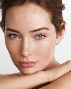 Woman with blue eyes and freckles, looking directly at the viewer