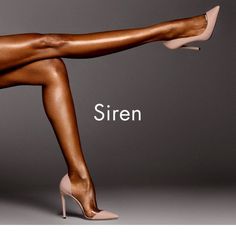 Two legs in nude high heels against a dark background