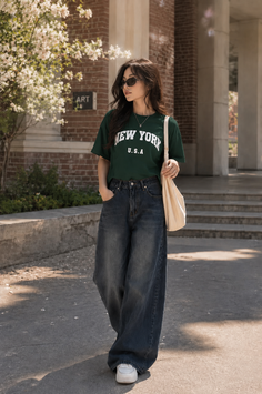 Woman in a green t-shirt and wide leg jeans walking outdoors