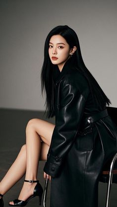 Woman with long black hair wearing a leather coat and high heels