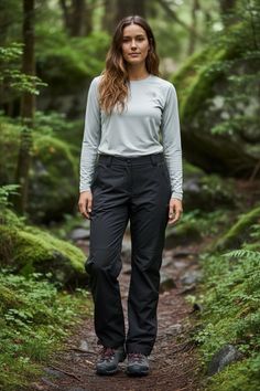 Woman in hiking attire standing on a forest path