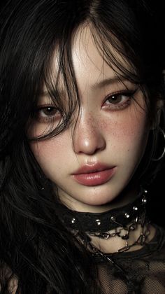 Close-up portrait of a woman with long black hair and a studded choker