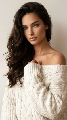 Woman with long wavy hair wearing an off-shoulder sweater