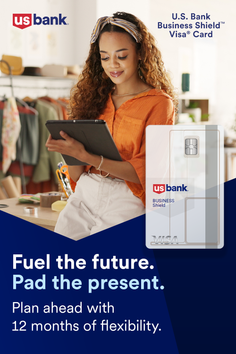 Woman with curly hair and a headband looking at a tablet indoors