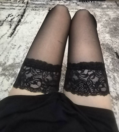 Person wearing black thigh-high stockings with lace trim
