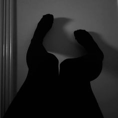 Silhouette of legs against a wall in black and white