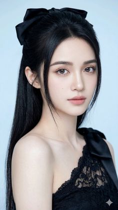 Woman with long black hair and a black bow in a lace top