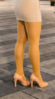 Person in a mini skirt, yellow tights, and high heels standing on a street