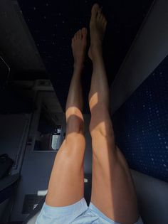 Bare legs with sunlight shining on them inside a train compartment