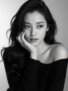 Woman with long dark hair wearing an off-shoulder top, in black and white