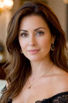 Woman with long brown hair wearing jewelry and an off-the-shoulder top