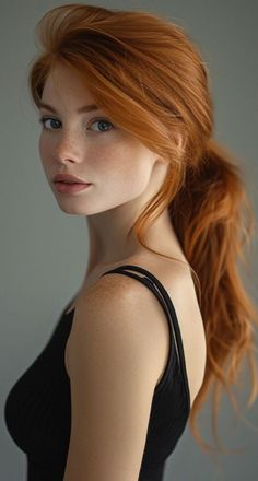 Woman with red hair and freckles wearing a black tank top