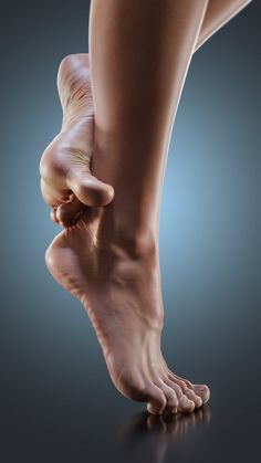 Close up of bare feet and legs against a dark background