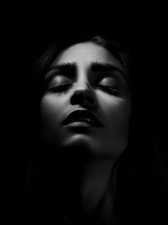 Black and white portrait of a woman with closed eyes and dramatic lighting