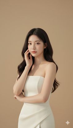 Woman in a white strapless dress posing in a studio with soft lighting