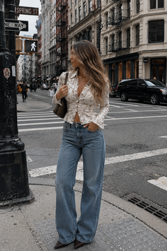 Woman in a floral shirt and wide leg jeans on a city street
