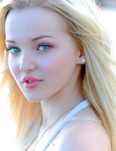 Blonde woman with blue eyes and pink lips wearing a pearl earring