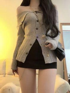 Woman in an off-shoulder top and black mini skirt with a shoulder bag indoors
