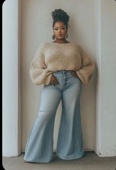Woman with a high bun and bell bottom jeans posing indoors