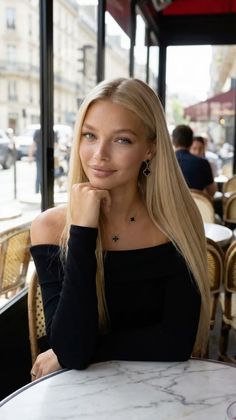 Blonde woman in a black off-shoulder top at a cafe